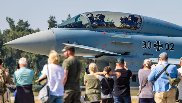 Besucher stehen beim Tag der Bundeswehr vor einem Kampfflugzeug vom Typ Eurofighter. Am Tag der Bundeswehr, der an neun Standorten begangen wird, werden im Fliegerhorst Holzdorf an der Landesgrenze zwischen Brandenburg und Sachsen-Anhalt dem Publikum insb