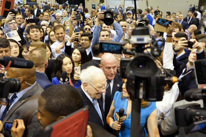 05.05.2018, USA, Omaha: Warren Buffett, Vorsitzender und CEO von Berkshire Hathaway (M) wird von Anlegern umringt, während er sich im CenturyLink Center bei Ausstellern umsieht. Er hat beim jährlichen Aktionärstreffen seiner Investmentgesellschaft Berkshi